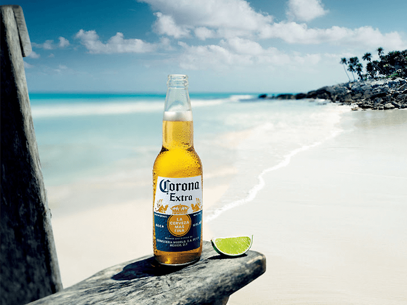 Botella de Cerveza Corona con limón en la playa