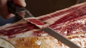 Cuchillo cortando pata de jamón ibérico