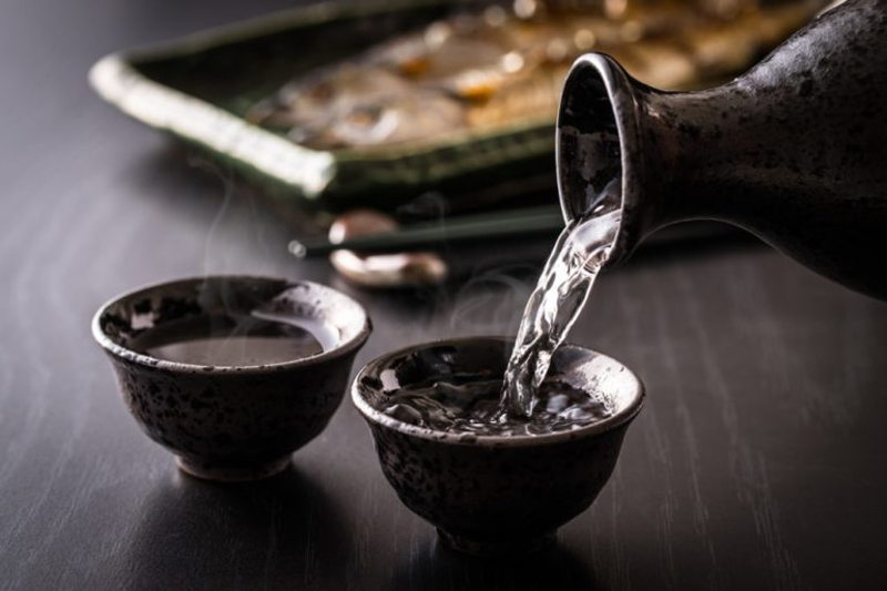 sirviendo dos basos de sake japonés
